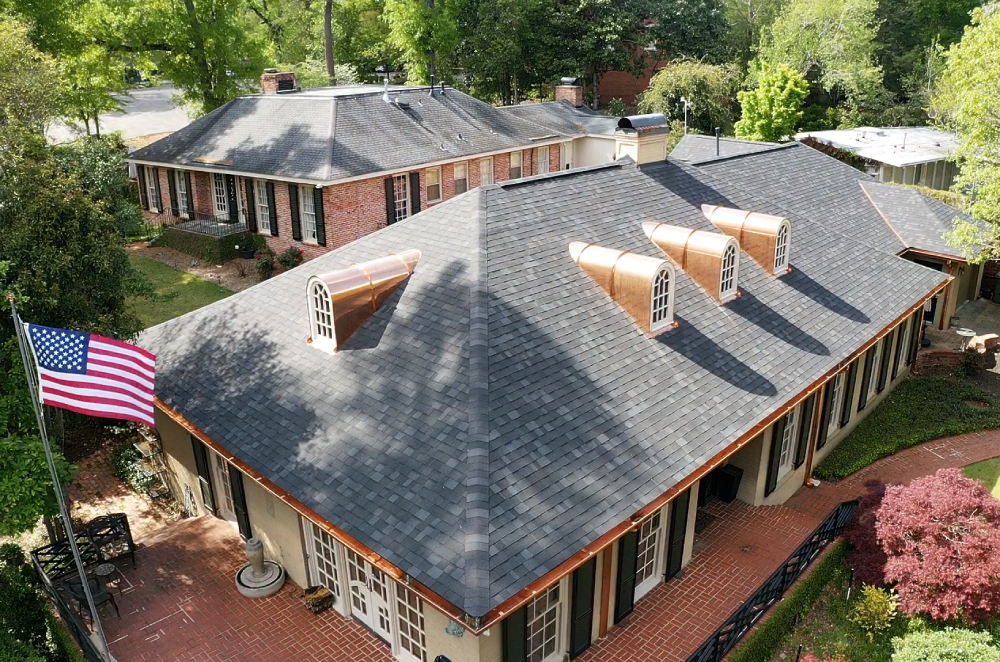 A newly installed residential asphalt shingle roof by I AM Roofing on a large Alabama home with custom copper dormers and gutters.